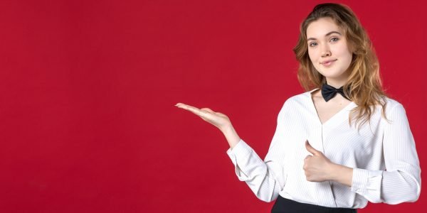 beautiful-waitress-woman-butterfly-neck-pointing-something-right-side-making-ok-gesture-red-background